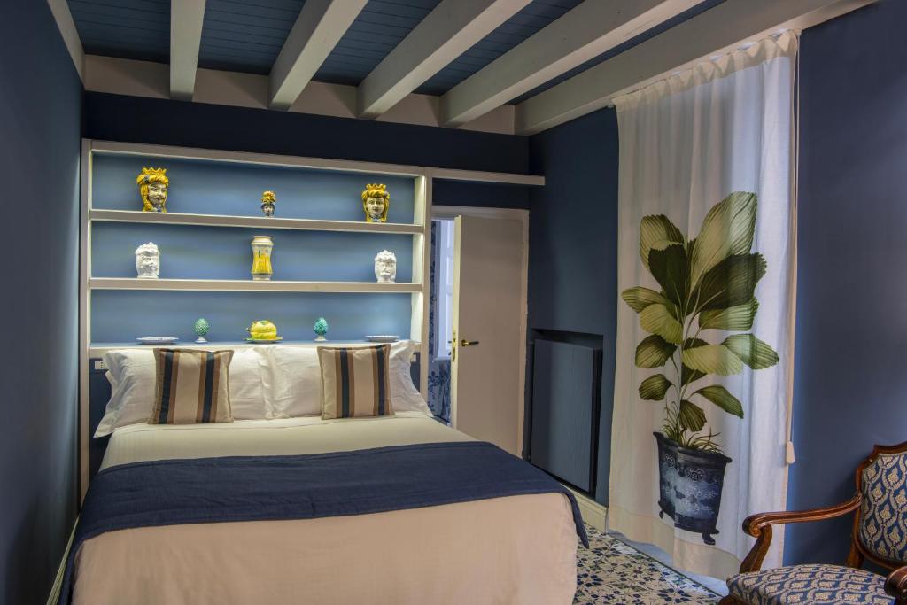 パレルモにあるPalazzo Arone dei Baroni di Valentinoの青い壁のベッドルーム1室(ベッド1台付)