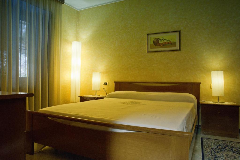 una camera con un letto, due lampade e una finestra di Rustico Giorgia a Mergozzo