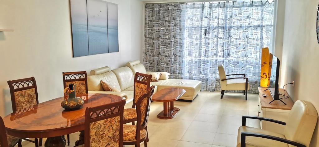 a living room with a table and chairs at Large apartment with sea view in Bat Yam
