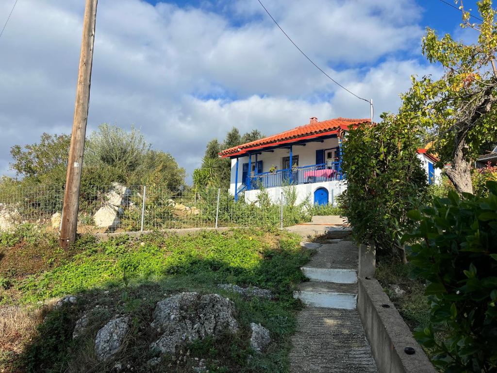 a house on a hill with a pathway leading to it at Villa Vrachos - uriges Steinhaus - in Vráchos