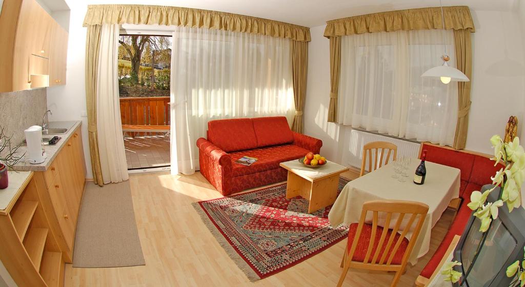 ein Wohnzimmer mit einem roten Sofa und einem Tisch in der Unterkunft Haus Ploner in Kastelruth