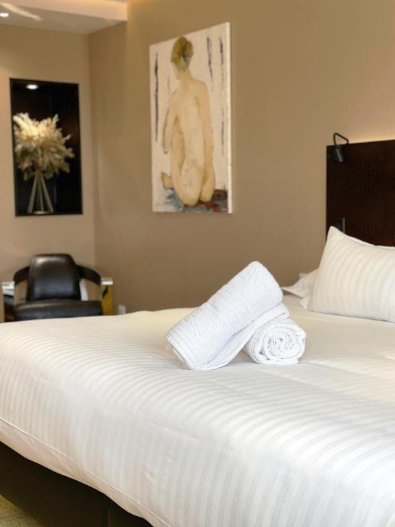a bedroom with a bed with two towels on it at Le Grand Hôtel Le Touquet-Paris-Plage in Le Touquet-Paris-Plage
