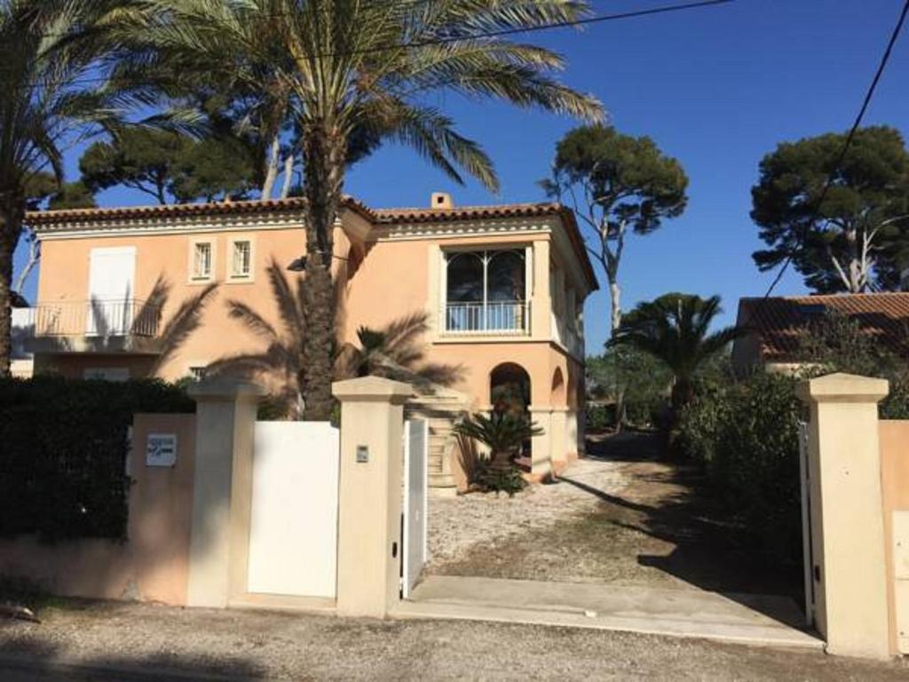 una casa con una puerta y una palmera en Echappée Bleue Immobilier - Villa Les Pesquier, en Hyères
