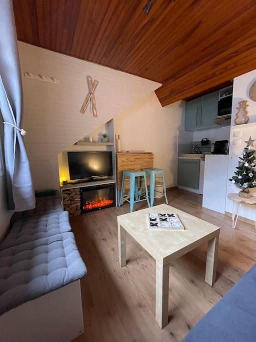 un salon avec une table et une cheminée dans l'établissement T2bis Idéal SKi et Cures Thermales, à Cauterets