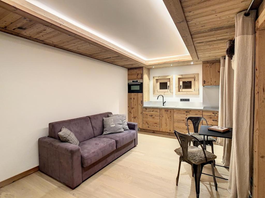 a living room with a couch and a kitchen at Plein soleil in Saint-Gervais-les-Bains