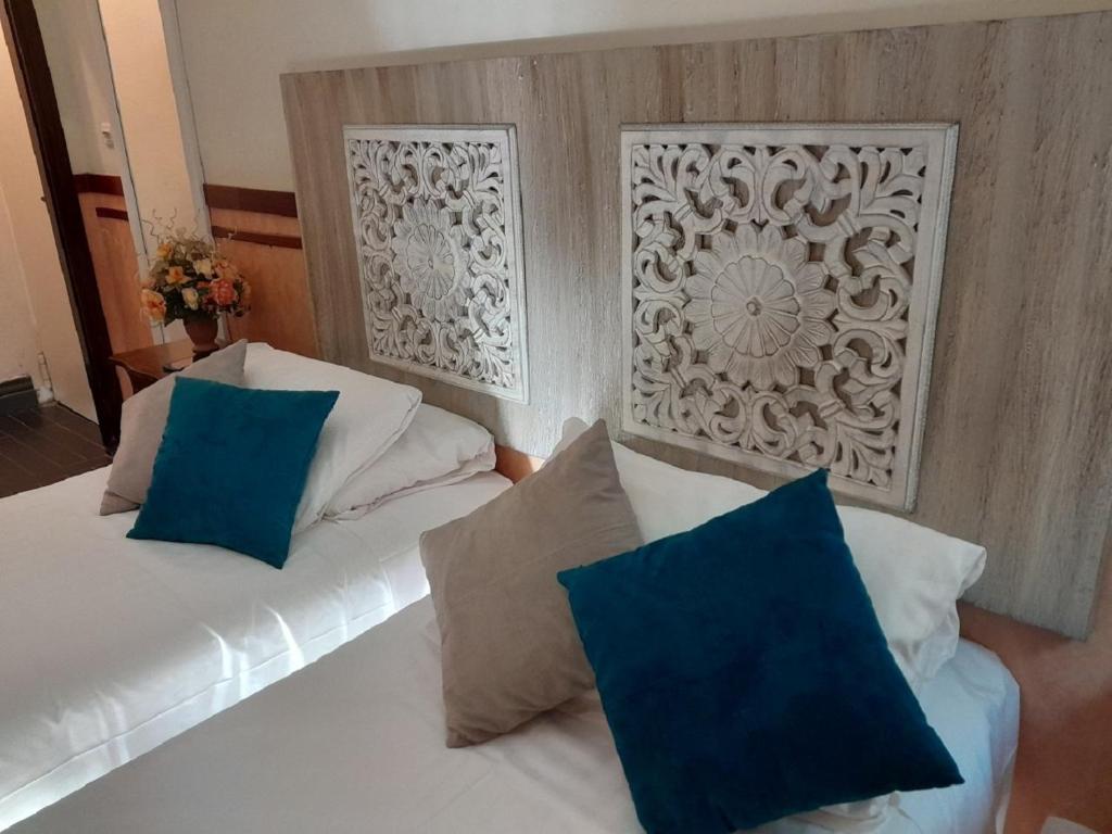 - une chambre avec un lit blanc et des oreillers bleus dans l'établissement Hotel San Felice, à Bologne