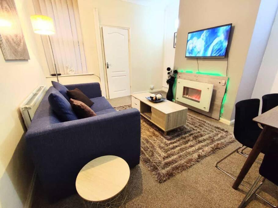 uma sala de estar com um sofá azul e uma lareira em Citylife Apartment em Old Walker