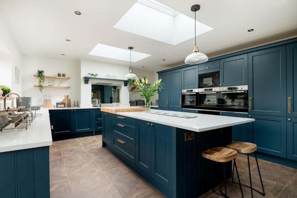a kitchen with blue cabinets and white counter tops at The Grand Barn in York