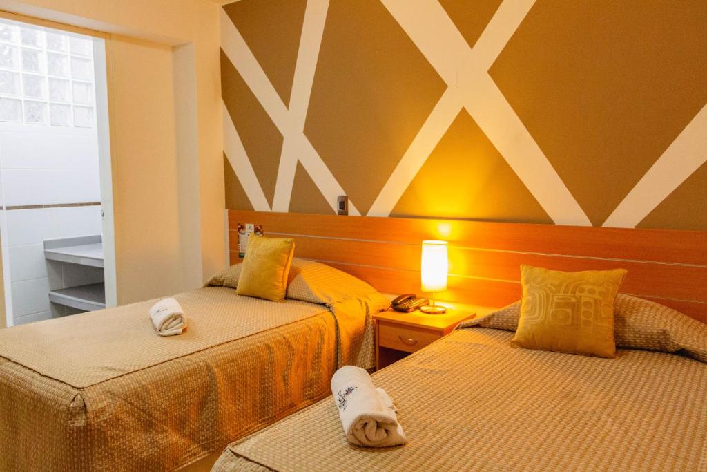 duas camas sentadas uma ao lado da outra num quarto em Hotel Mochiks em Chiclayo