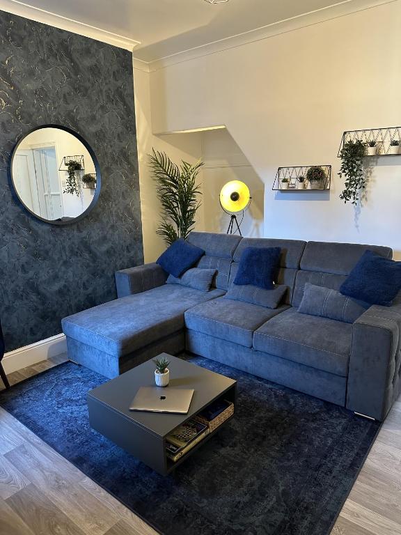 a living room with a blue couch and a mirror at 23 Horner Street York in York