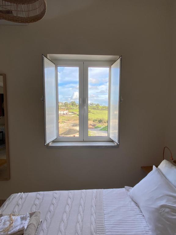 1 dormitorio con cama y ventana en The Little Owls Nest Castro Verde, en Castro Verde