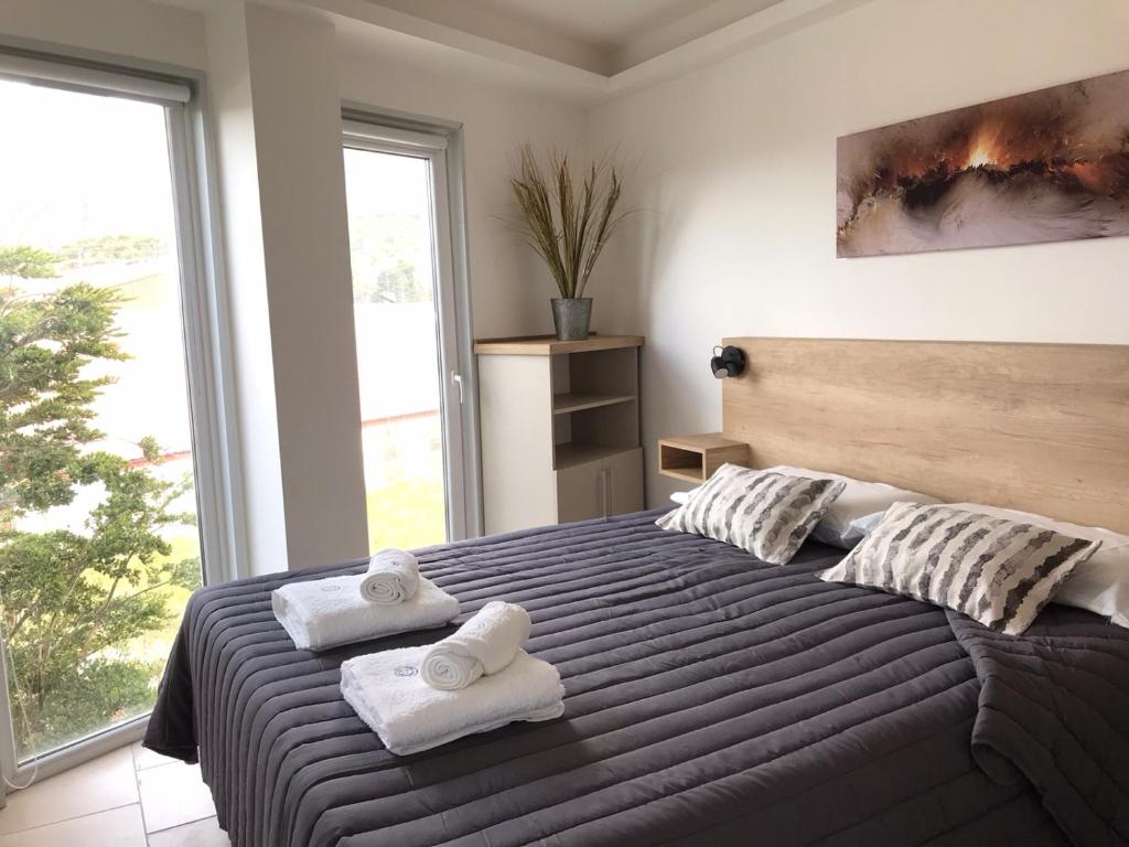 1 dormitorio con 1 cama grande y toallas. en D&G Ush II en Ushuaia
