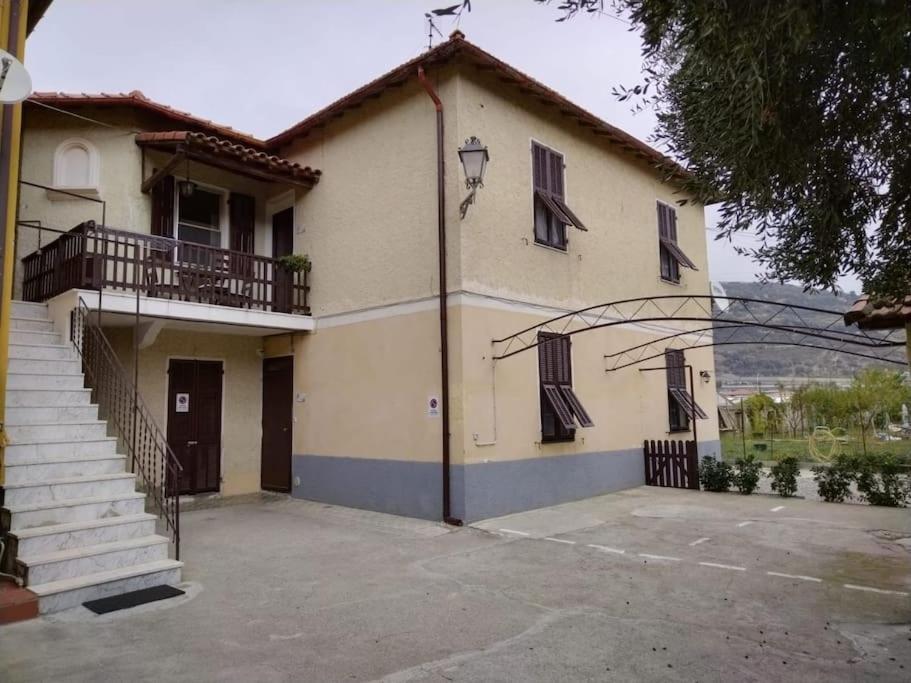 a large house with a staircase in a parking lot at Casa Sveva, a pochi passi dalle spiagge e dal centro di Arma di Taggia. in Arma di Taggia