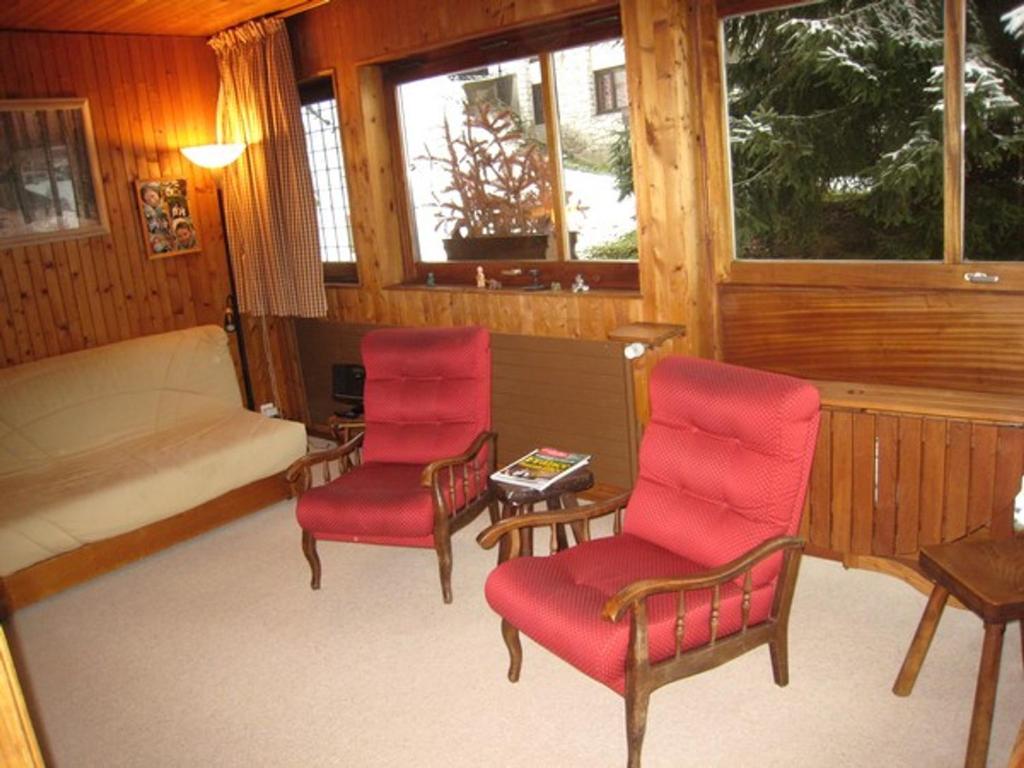 ラ・クリュサにあるAppartement La Clusaz, 2 pièces, 6 personnes - FR-1-459-16の赤い椅子2脚とベッド1台が備わる客室です。