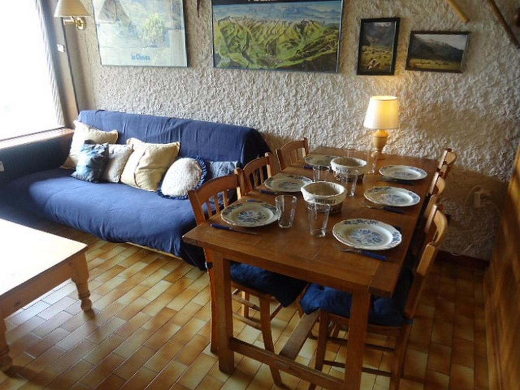 un salon avec une table et un canapé bleu dans l'établissement Duplex à La Clusaz avec cheminée et balcon, 2 ch, parking - FR-1-459-12, à La Clusaz