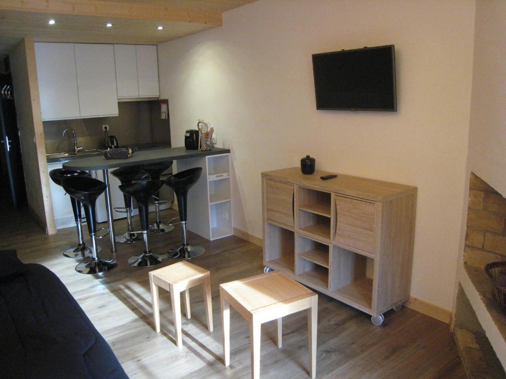 a living room with a kitchen with a counter and stools at Studio La Clusaz, 1 pièce, 4 personnes - FR-1-459-62 in La Clusaz