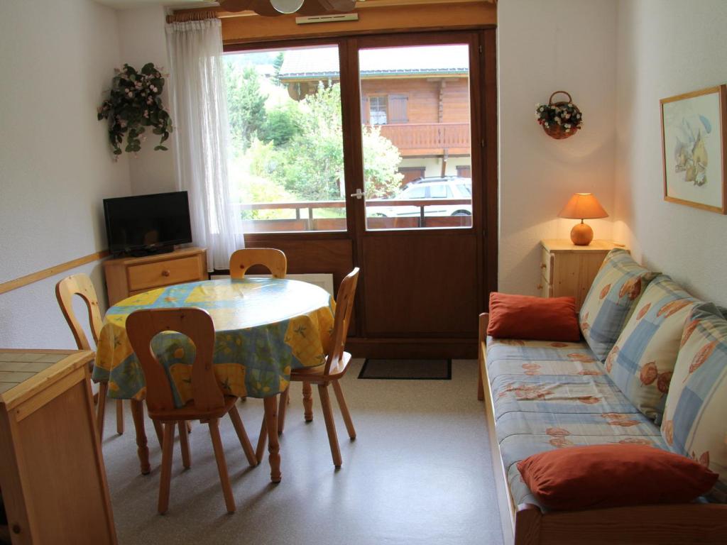 Appartement La Clusaz, 2 pièces, 4 personnes - FR-1-459-92 في لا كلوساز: غرفة معيشة مع طاولة وأريكة