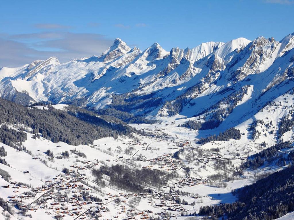 an aerial view of a snowy mountain range with a town at Appartement La Clusaz, 2 pièces, 4 personnes - FR-1-459-92 in La Clusaz