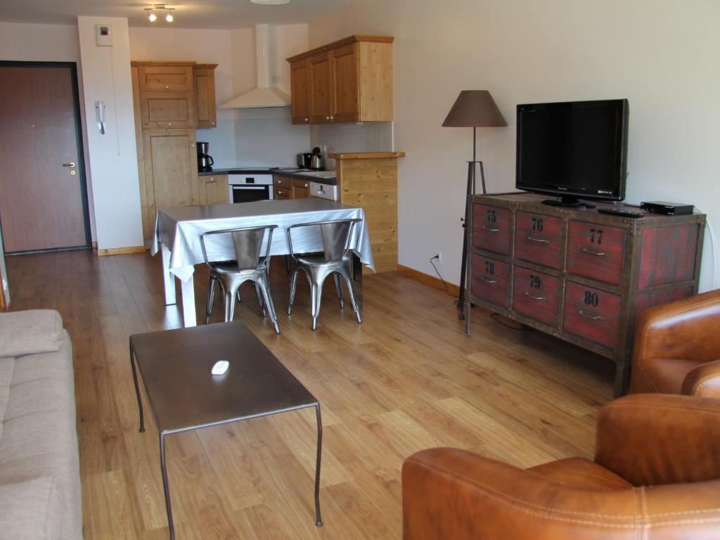 un salon avec une table et une cuisine dans l'établissement Charmant appartement au centre du village, proche des stations de ski - 4 personnes - FR-1-459-163, à Saint-Jean-de-Sixt