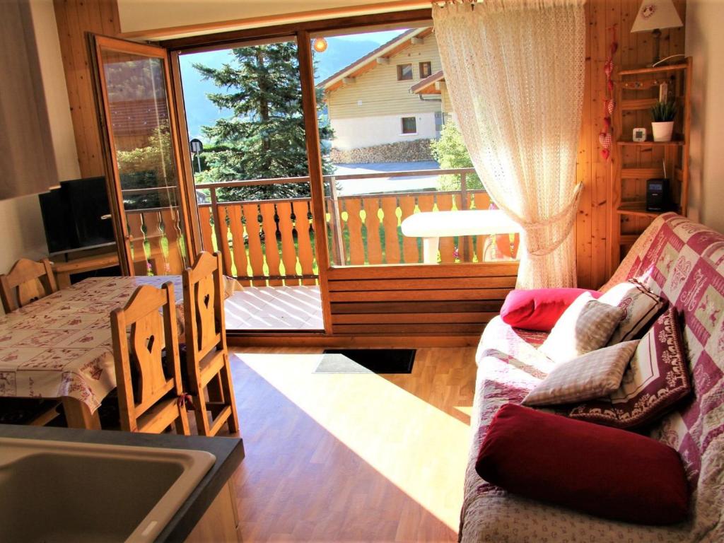 d'un salon avec un canapé et un balcon. dans l'établissement Appartement cosy avec balcon, parking individuel et WiFi à Saint-Jean-de-Sixt - FR-1-459-165, à Saint-Jean-de-Sixt