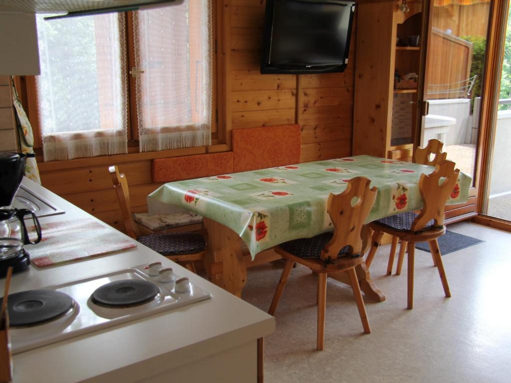 une cuisine avec une table, des chaises, une table et une télévision dans l'établissement Appartement pour 4-6 personnes au cœur du village, Saint-Jean-de-Sixt (BLA003) - FR-1-459-162, à Saint-Jean-de-Sixt