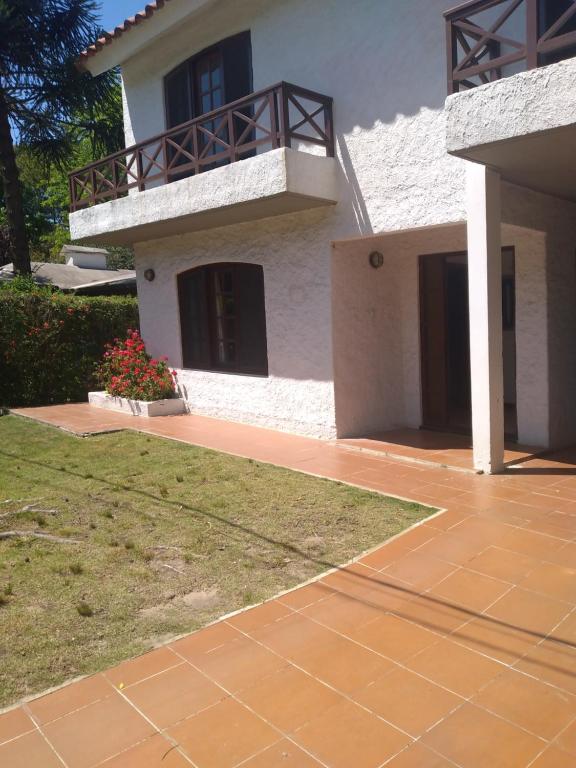a white house with a balcony and a yard at Apartamento independiente en planta baja. Zona residencial in Piriápolis