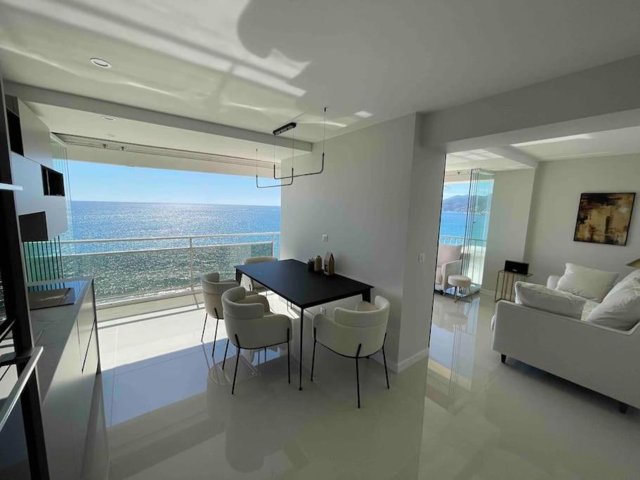 een woonkamer met een eettafel en uitzicht op de oceaan bij Vue mer exceptionnelle, appartement unique de luxe in Cannes
