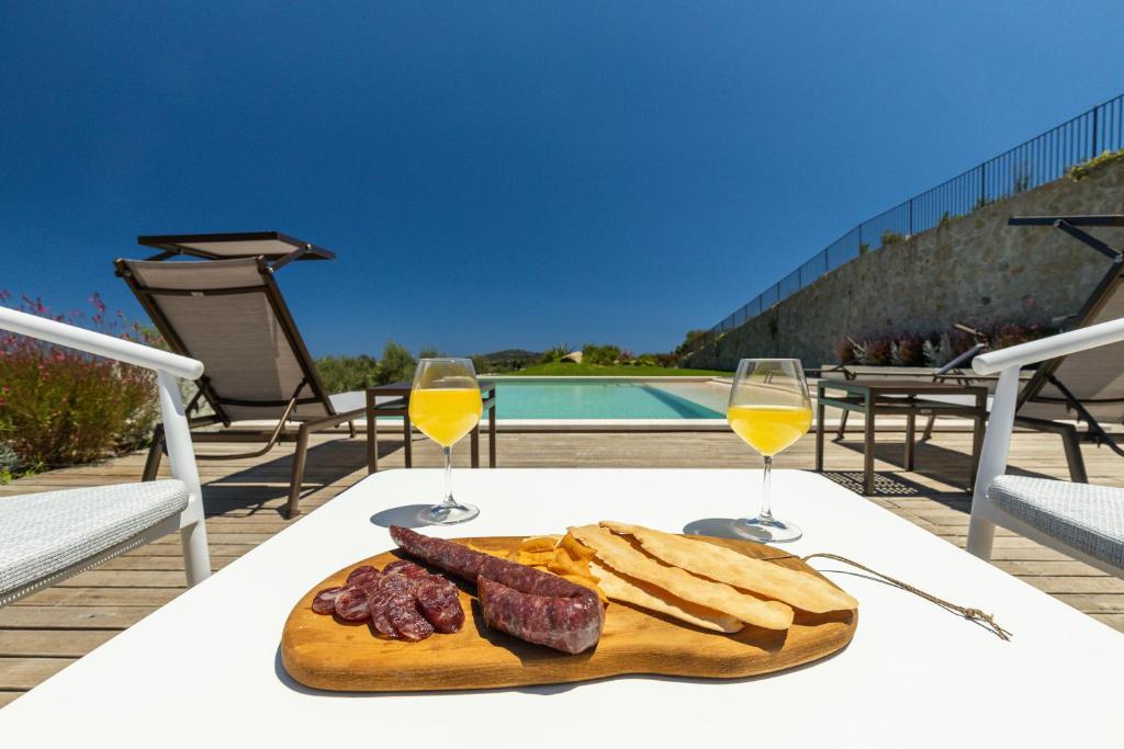 un piatto di cibo su un tavolo con due bicchieri di vino di Dimore Santa Justa a Tortolì