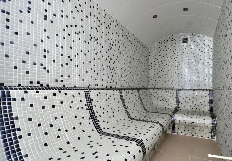 a bathroom with two benches in a room with tiled walls at Квартира в Алании на берегу Клеопатры in Alanya