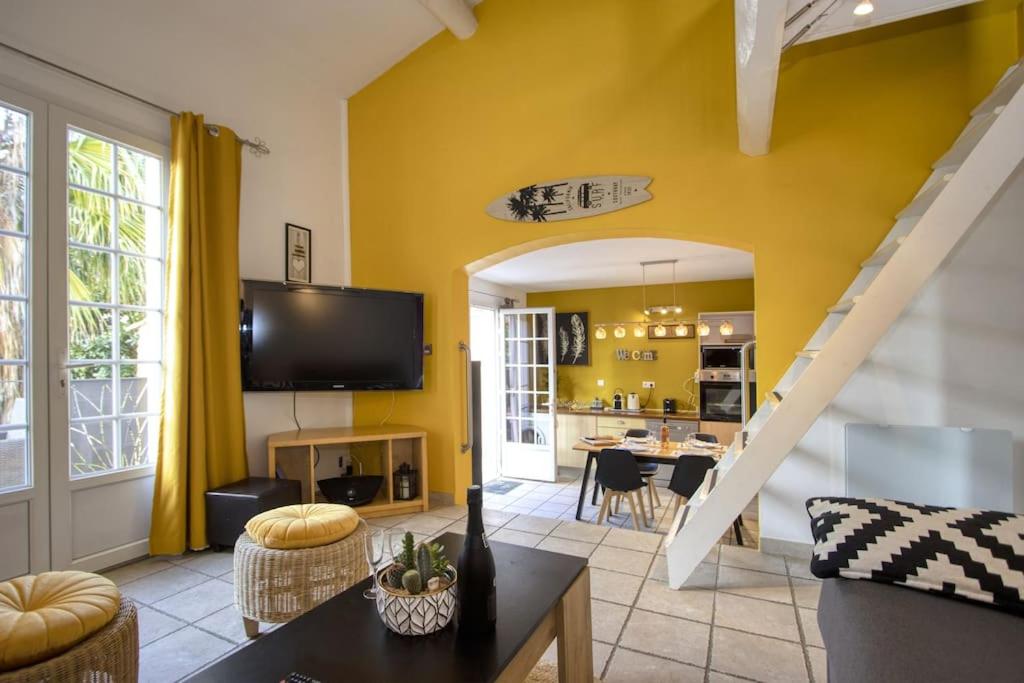 a living room with yellow walls and a tv at Villa ESPERANCE- appartement entier T2 in La Ciotat