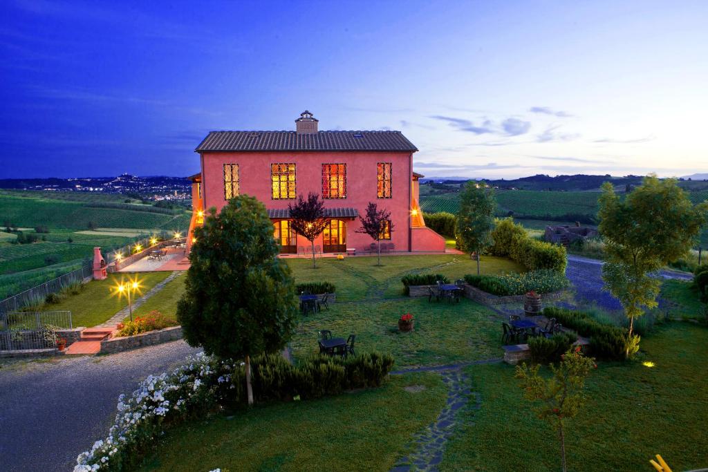 Una gran casa roja con luces encima. en Agriturismo Borgo Vigna Vecchia en Cerreto Guidi