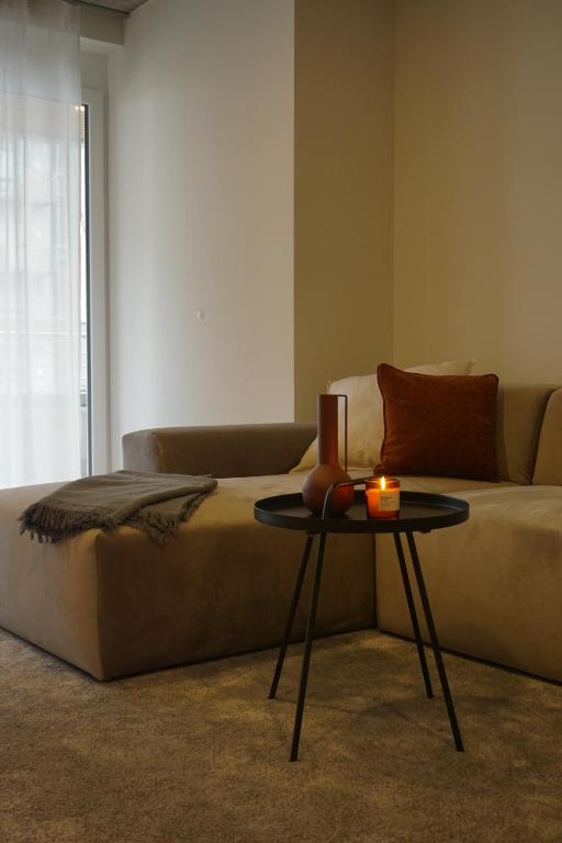 ein Wohnzimmer mit einem Sofa und einem Tisch mit einer Kerze in der Unterkunft Schönes Neubau Serviced-Apartment mit Parkplatz in Bruchsal