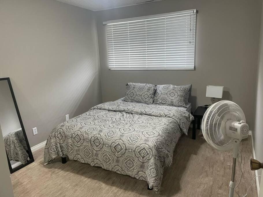 a bedroom with a bed and a fan and a window at Wonderful 2-bedroom apartment in Camrose