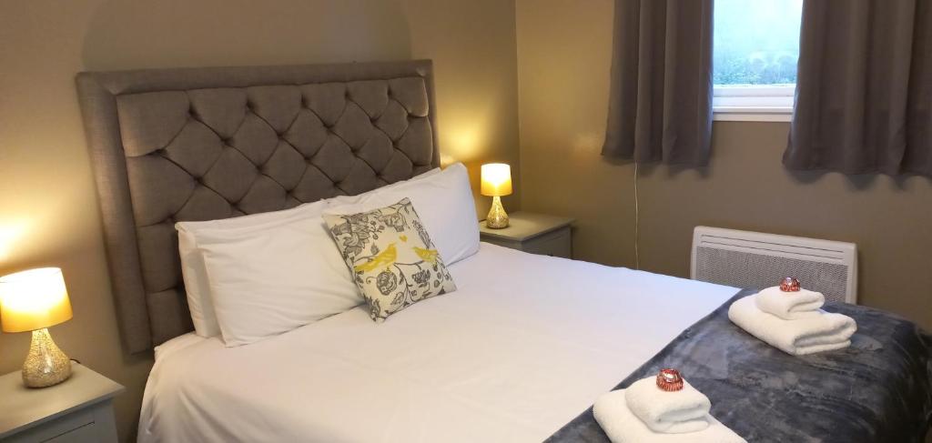 a bedroom with a bed with towels on it at Highland Bridge Hotel in Spean Bridge