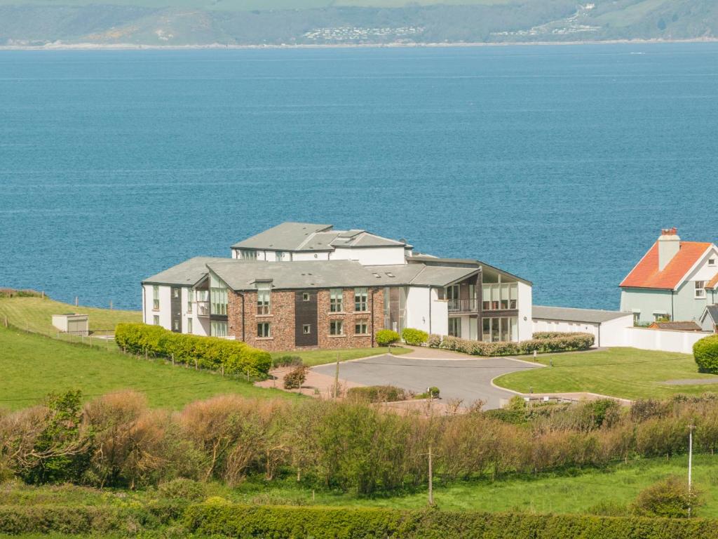 un grande edificio su una collina vicino all'oceano di 10 Oceans Edge a Kingsbridge