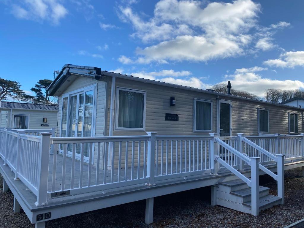 a mobile home with a large deck at Glade 50 Bideford Bay Holiday Park in Bideford