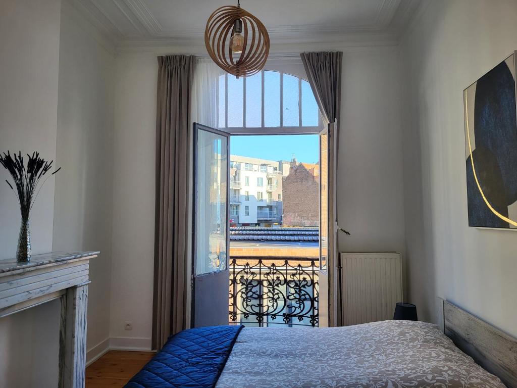 ein Schlafzimmer mit einem Bett und einem großen Fenster in der Unterkunft Brussels Bed & Blockchain Private rooms with shared bathroom in Brüssel