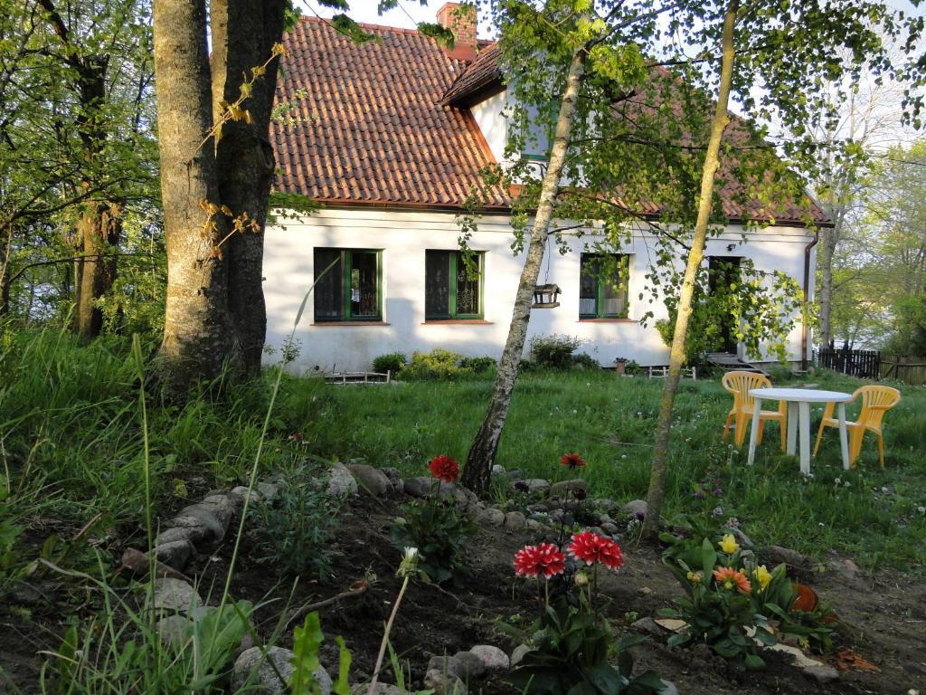 a garden in front of a white house at Agroturystyka Żywe in Kruklanki