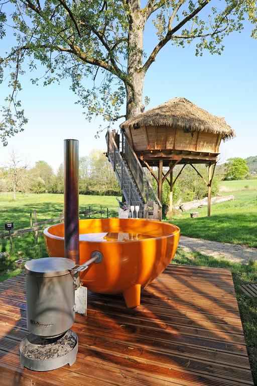 - un lavabo orange assis au-dessus d'une terrasse en bois dans l'établissement Les Insolites du Domaine de Suzel, à Vignieu
