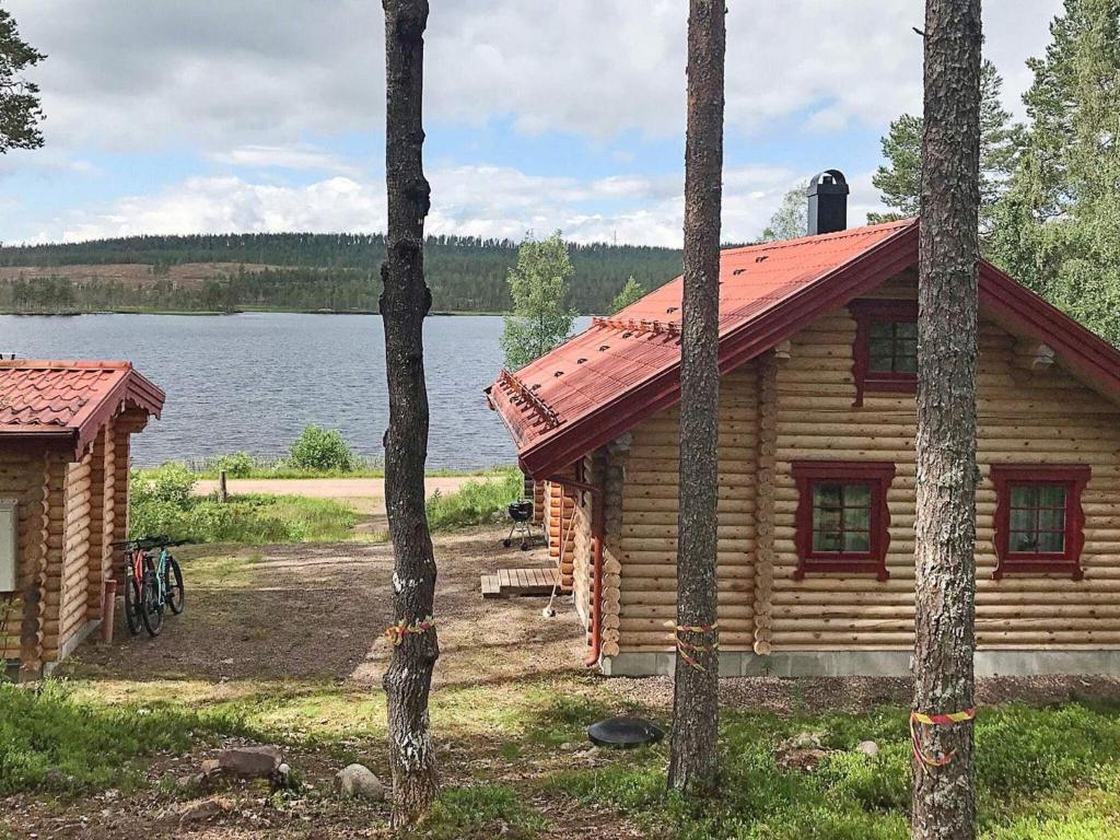 a log cabin in the woods next to a lake at Two-Bedroom Holiday home in Sälen 2 in Tandådalen