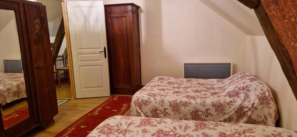 a small room with two beds and a door at Gîte de groupe du Château de la Mézière in Lunay