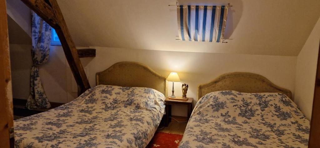 two beds in a small bedroom with a window at Gîte de groupe du Château de la Mézière in Lunay