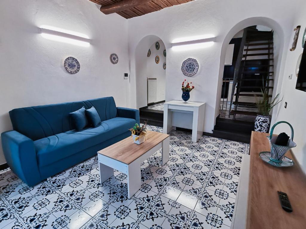 un soggiorno con divano blu e tavolo di Casagiugiù a Vietri