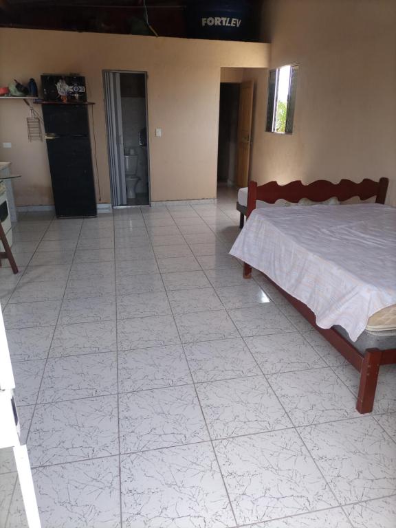 1 dormitorio con 1 cama y suelo de baldosa en Recanto da Paz en Solemar