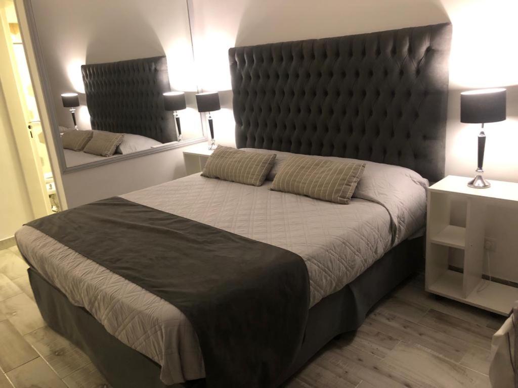 a bedroom with a large bed with a large headboard at Las Naciones 1710 in Buenos Aires