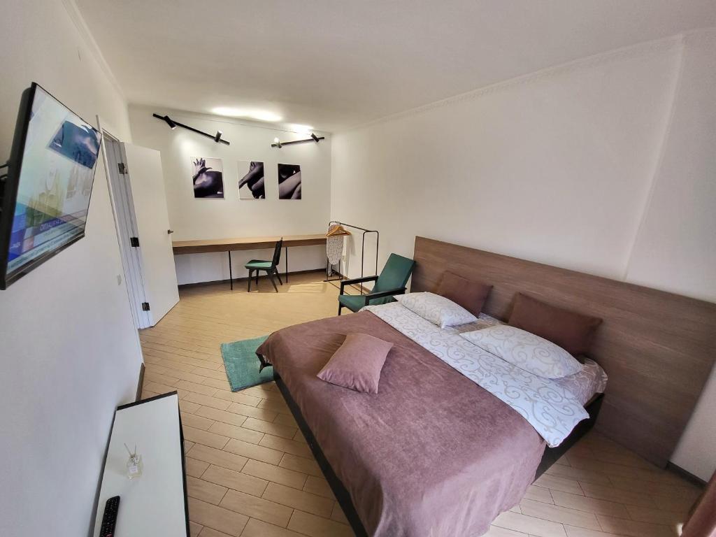 ein Schlafzimmer mit einem großen Bett und einem Schreibtisch in der Unterkunft Like Home on Mikhnovskogo in Iwano-Frankiwsk