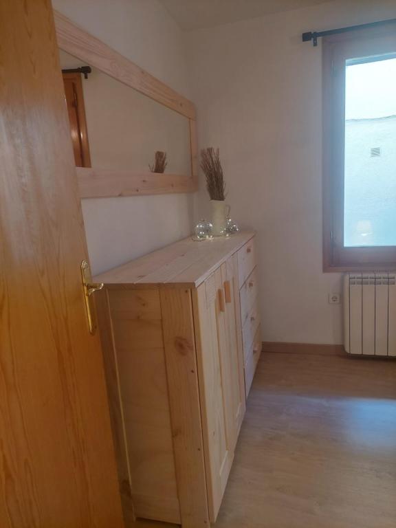 um quarto com um armário de madeira e uma janela em Apartaments Albiñana em Llavorsí