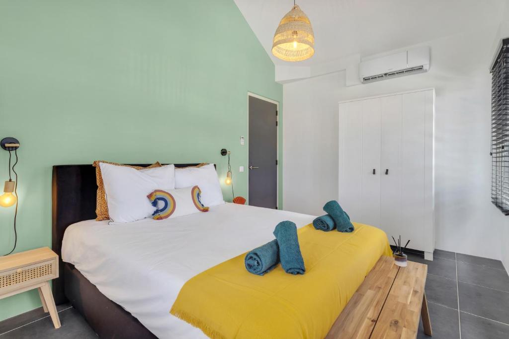 - une chambre avec un lit et 2 serviettes bleues dans l'établissement Brand new Two Bedroom Apartment at the Water, à Kralendijk