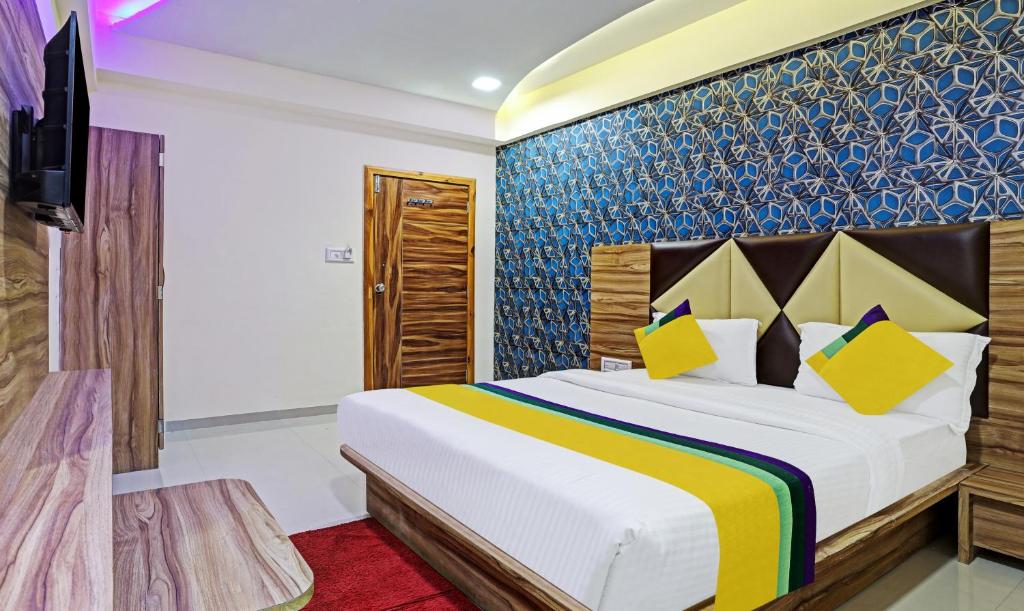um quarto com uma cama grande e uma televisão em Itsy By Treebo - Rk Palace em Vadodara