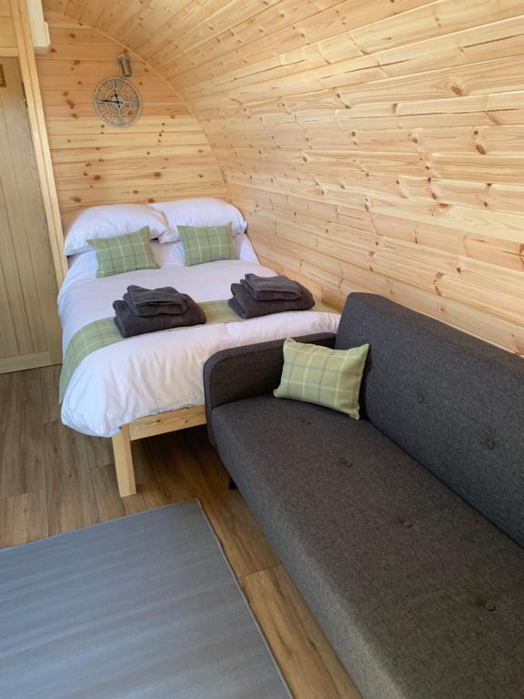 a bedroom with a bed and a couch in a room at Loch an Eilean Pod Isle of South Uist in Pollachar